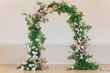 Floral arch composed of lush greenery and various flowers creating a stunning focal point. Perfect setting for events, weddings, or photo opportunities. clipart