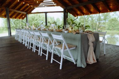 Zarif çiçek süslemeleri, gurme yemekleri ve yumuşak ışıklandırma içeren güzel düzenlenmiş bir masa. Özel durumlar ve toplantılar için mükemmel..