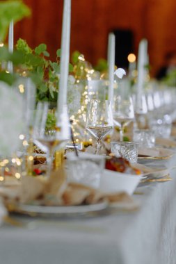 Mumların, taze çiçeklerin ve gurme tabakların olduğu güzel bir masa. Samimi bir yemek için mükemmel..