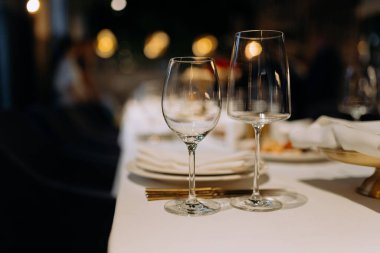 Konforlu ve davetkar bir yemek atmosferiyle çevrili iki şarap kadehiyle güzel bir masa, unutulmaz bir yemek deneyimi için mükemmel..