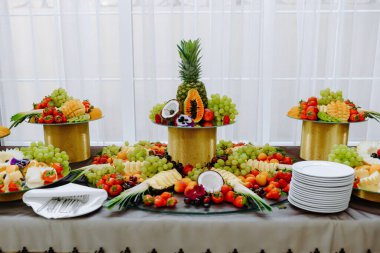 Çilekler, üzümler ve kavunlar da dahil olmak üzere çeşitli meyvelerin göz kamaştırıcı bir şekilde sergilenmesi zarif bir etkinlik ya da kutlama için güzelce düzenlenmiştir..