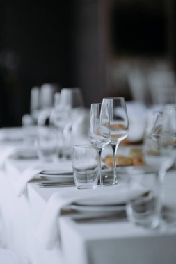 Pırıl pırıl cam eşyalar ve katlanmış peçeteler üzerine odaklanmış güzel bir masa. Lüks yemek deneyimleri için mükemmel..