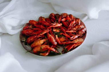 Pürüzsüz beyaz bir yüzey üzerinde sunulan güzel, canlı, pişmiş kerevit tabağı deniz ürünleri severler için mükemmeldir..