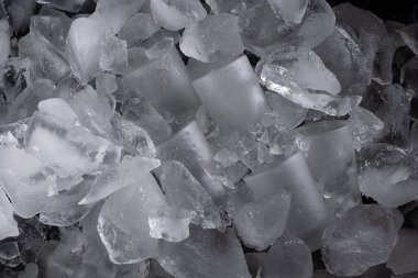 Parçalanmış buz küpleri ve buzla çevrili buzlu bardakların yakın çekim görüntüsü ferahlatıcı ve serin bir atmosfer yaratıyor..