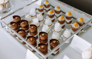 Çikolata ve kremalı tatlılar, mutfak sanatının sergilenmesi ve her etkinlik için sunum becerileri içeren enfes mini hamur işlerinin güzel bir düzenlemesi..