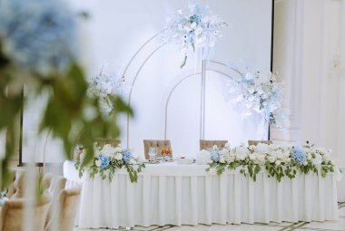 Güzel düzenlenmiş düğün masası canlı çiçeklerle süslenmiş romantik ve zarif bir atmosfer yaratıyor. Özel kutlamalar için mükemmel..