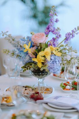 Şık bir yemek atmosferinde özel günler ve kutlamalar için ideal olan gurme yemeklerle birlikte güzel bir çiçek süsü..