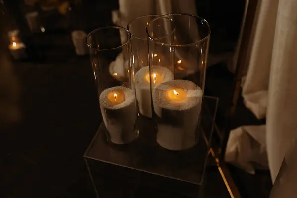 Loş bir alanı aydınlatan, ılık ve sükunet ortamı yaratan, sükunet ve dekoratif mumların sakin bir görüntüsü..