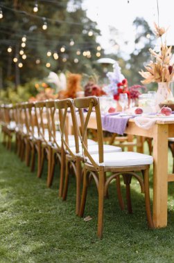 Zarif dekorlarla süslenmiş göz kamaştırıcı bir açık masa. Parıldayan ışıkların altında özel bir toplantı için mükemmel..