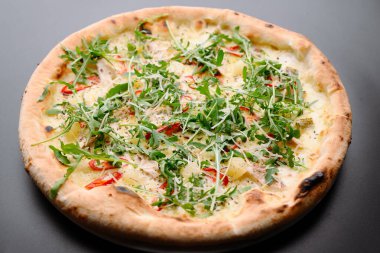 Pizzacılar için mükemmel roka, biber ve peynirle kaplı çıtır kıtır bir pizzanın yer aldığı lezzetli bir pizza..