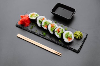 Canlı suşi rulolarının tadını çıkarın. Taze malzemelerle süslenmiş, wasabi ve turşulu zencefil, her aşçılık için mükemmel..