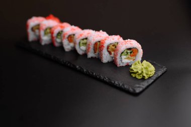 Rengarenk bir suşi tabağı bir tutam taze wasabi 'nin yanında yuvarlanıyor. Mutfak ziyafeti için mükemmel..