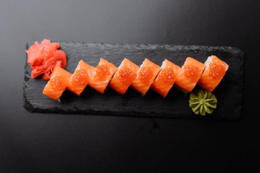 Suşi sunumunda somon, wasabi ve turşulu zencefil kullanılıyor..