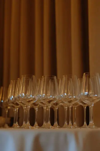 Masanın üzerine dizilmiş bir dizi köpüklü şarap kadehi. Arka planda sıcak, yumuşak bir ışık olan özel bir olayı bekliyorlar..
