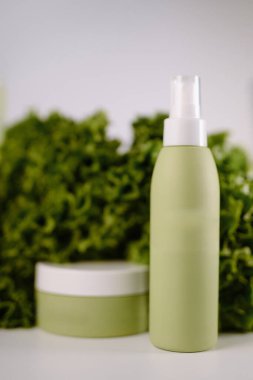 Çevre dostu kozmetik konteynırlar yapraklı arka planda, organik cilt bakımı ya da güzellik damgası için mükemmel..