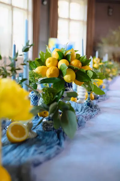 Vazolarda sergilenen parlak limonlar ve yeşil yapraklar etkinlikler için taze ve zarif bir masa süsü oluşturur..