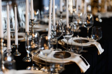 Şatafatlı resmi yemek masası, cam tabaklar, uzun mumlar, lüks etkinlikler için mükemmel..