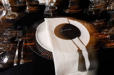 Şatafatlı yemek masası düzenlemesi, cam eşyalar, beyaz peçete ve özel etkinlikler için yuvarlak kart..