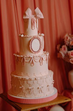 Gösterişli, pembe katlı, süslü bir pasta, düğünler ya da özel kutlamalar için mükemmel, zarif bir arka plan..