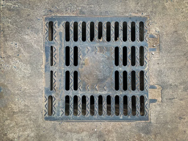 セメント床の汚い鋼マンホール — ストック写真