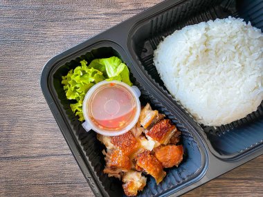 Yemek kabında yasemin pilavı ve kızarmış domuz eti.