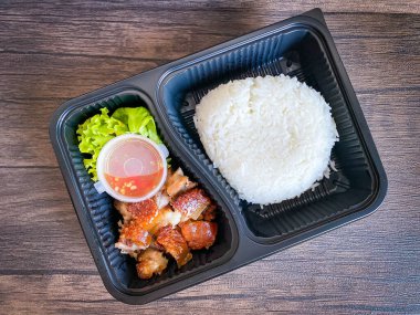 Yemek kabında yasemin pilavı ve kızarmış domuz eti.