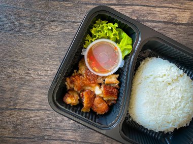 Yemek kabında yasemin pilavı ve kızarmış domuz eti.