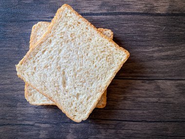 Tahta arka planda yenmeye hazır buğday ekmeği.