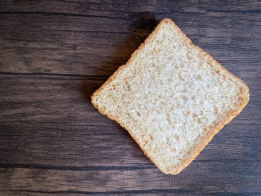 Tahta arka planda yenmeye hazır buğday ekmeği.