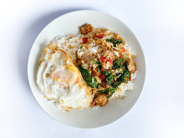 Üstünde kızarmış domuz göbeği, Tayland fesleğeni ve sahanda yumurta var.