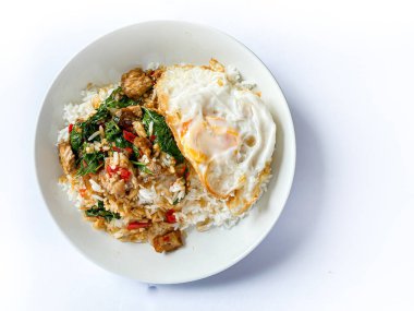 Üstünde kızarmış domuz göbeği, Tayland fesleğeni ve sahanda yumurta var.