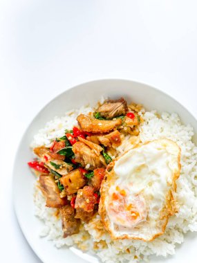 Üstünde kızarmış domuz göbeği, Tayland fesleğeni ve sahanda yumurta var.
