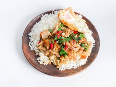 Üstünde kızarmış domuz göbeği, Tayland fesleğeni ve sahanda yumurta var.