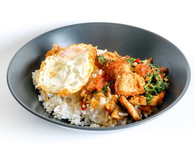 Üstünde kızarmış domuz göbeği, Tayland fesleğeni ve sahanda yumurta var.