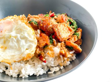 Üstünde kızarmış domuz göbeği, Tayland fesleğeni ve sahanda yumurta var.