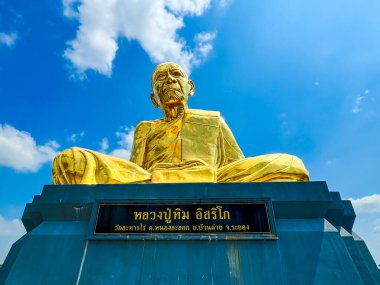 Rayong Tayland - 30 Nisan 2024. Lahan Rai tapınağındaki bir keşişin (Luang Pu Tim) büyük altın heykeli, burası insanlar ve turistler arasında popülerdir. Dua etmek ve dua etmek için gelenler..