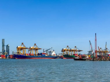 Bangkok Thailand - 30 Nov 2024:  The biggest port in Bangkok with loaded freight ship and cargo handling equipment on the side of Chao Phraya river. clipart