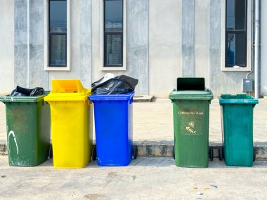 Binanın yanında farklı renkte çöp var.