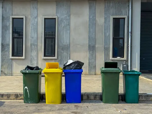 Binanın yanında farklı renkte çöp var.