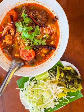 Nam Ngiao adında geleneksel Tayland erişte çorbası yanında taze sebzelerle servis edilir..