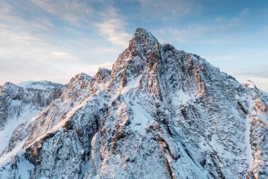 Snow covered mountain range on coastline in winter, Norway. Senja panoramic aerial view landscape nordic snow cold winter norway ocean cloudy sky snowy mountains. Troms county, Fjordgard
