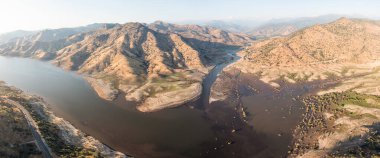 Dağ kanyonundaki çamurlu dere. Yaz başında sel baskınından sonra nehir. Kuru kayalıklar nehir yatağını oluşturur. Doğal afetler konsepti. Küresel ısınma Hava görünümü.