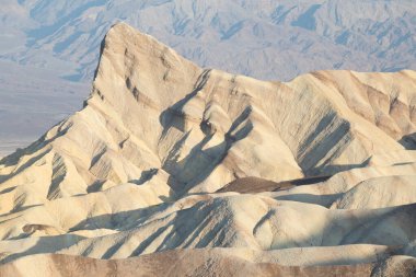 Mesquite Düzlüğü Kum Tepesi 'nde, Kaliforniya' daki Ölüm Vadisi Ulusal Parkı 'nda güneş doğarken oluşan doğal dalgalı kum deseni manzarası. Mojave çölünde sabah yürüyüşü Amargosa sıradağları arkada.