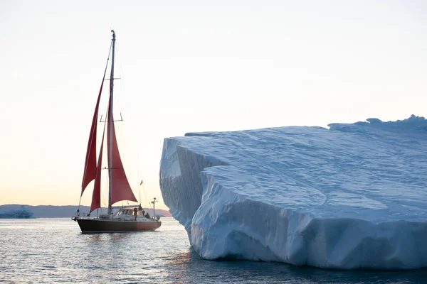 Kırmızı Yelkenli Yelkenli Gün Doğumunda Buzdağları Arasında Dolaşır Disko Körfezi — Stok fotoğraf