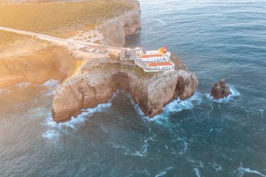 Cabo de So Vicente 'nin engebeli uçurumları üzerinde, Farol do Cabo de So Vicente deniz feneri, Atlantik Okyanusu' nun panoramik manzarası, Algarve bölgesinde bir tatil yeri haline getiriyor. Hava görünümü.