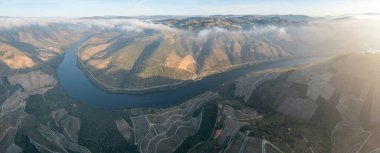 Pinhao köyü yakınlarındaki Douro Vadisi 'nde romantik günbatımında teraslı üzüm bağlarının hava manzarası. Portekiz 'de seyahat ve Portekiz' deki en güzel liman şarap çiftliği Unesco 'da seyahat kavramı.