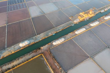 Sicilya, Marsala 'daki tuz buharlaştırma gölünde gün batımı, İtalya' daki Trapani tuz düzlükleri ve Sicilya 'daki eski yel değirmeni. Güneşli ve güzel bir günde.