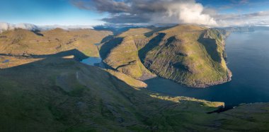 Köy yolu ile Faroe Adaları 'nın güneşli yaz manzarası. Danimarka. Kenar mahallelerin muhteşem sabah manzarası. Seyahat konsepti arka planı.