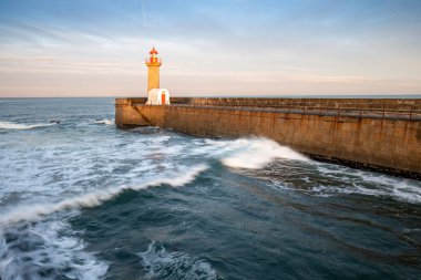 Eski iskelede güzel bir gün batımı ve nehir ağzındaki Felgueiras Deniz feneri Douro, Porto, Portekiz Büyük deniz dalgası gün batımında sıçrıyor.