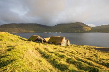 Çim çatılı evler, Bour köyü, vajina adası, Faroe adaları, Danimarka, Avrupa. Tipik çim tepeli evleri olan güneşli Saksun köyü manzaralı evler. Seyahat konsepti arka planı.